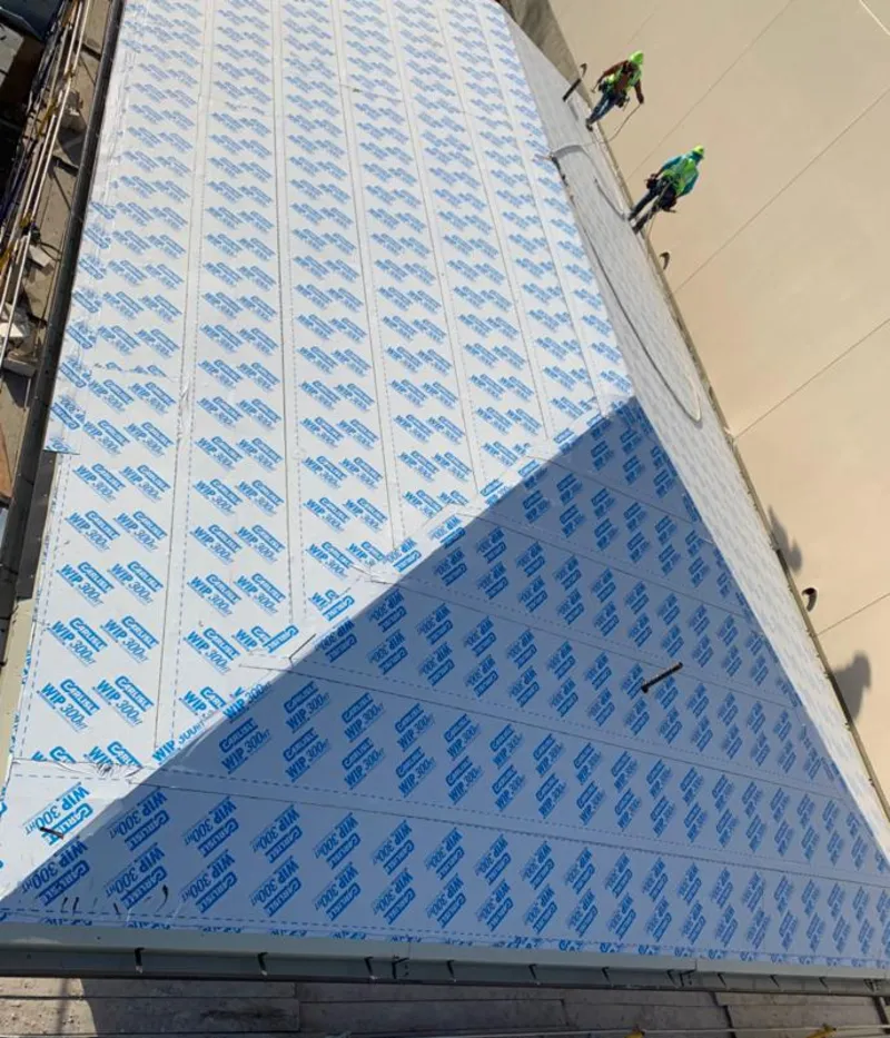 Professional roofers installing underlayment on a metal roof in Milltown